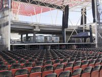 empty seats inside a stadium with a stage and an entrance behind them near an arena