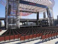 empty seats inside a stadium with a stage and an entrance behind them near an arena