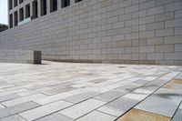 there is an empty stone block outside the building on a sunny day on a sidewalk