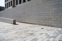 there is an empty stone block outside the building on a sunny day on a sidewalk