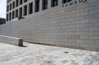 there is an empty stone block outside the building on a sunny day on a sidewalk