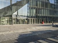 an empty stone sidewalk with some glass buildings around it on the other side of the street