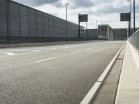 the empty street near an airport is surrounded by large billboards that read ber