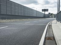 the empty street near an airport is surrounded by large billboards that read ber