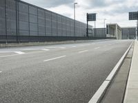 the empty street near an airport is surrounded by large billboards that read ber