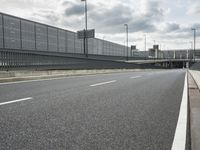 the empty street near an airport is surrounded by large billboards that read ber