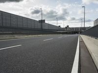 the empty street near an airport is surrounded by large billboards that read ber