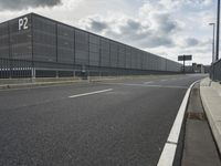 the empty street near an airport is surrounded by large billboards that read ber