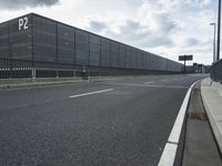 the empty street near an airport is surrounded by large billboards that read ber