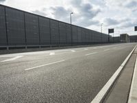 the empty street near an airport is surrounded by large billboards that read ber