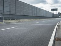 the empty street near an airport is surrounded by large billboards that read ber