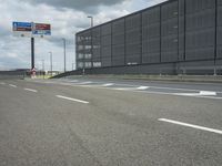 the empty street near an airport is surrounded by large billboards that read ber