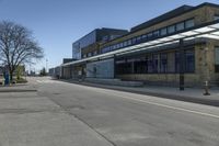 empty street with benches on either side and large glass windows on the other side of it