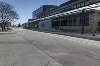 empty street with benches on either side and large glass windows on the other side of it