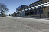 empty street with benches on either side and large glass windows on the other side of it