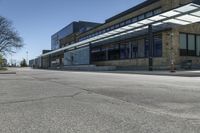 empty street with benches on either side and large glass windows on the other side of it