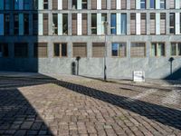 an empty street is seen during the daytime sunlight from high buildings in an urban area