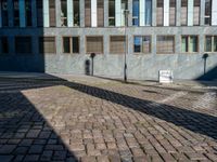 an empty street is seen during the daytime sunlight from high buildings in an urban area