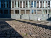 an empty street is seen during the daytime sunlight from high buildings in an urban area