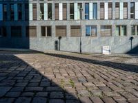 an empty street is seen during the daytime sunlight from high buildings in an urban area