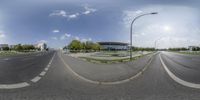 an empty street with a building on the opposite corner as seen from a fisheye lens