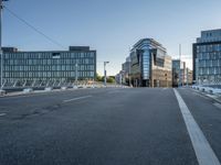 the empty street in front of some building with a glass facade next to each other