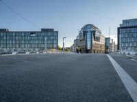 the empty street in front of some building with a glass facade next to each other