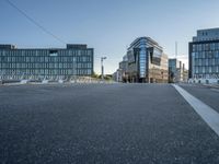 the empty street in front of some building with a glass facade next to each other