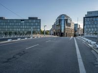 the empty street in front of some building with a glass facade next to each other