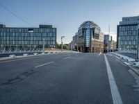 the empty street in front of some building with a glass facade next to each other