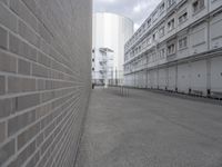 a man is walking through an empty street in the city that's lined with tall buildings