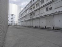 a man is walking through an empty street in the city that's lined with tall buildings