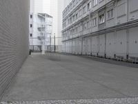 a man is walking through an empty street in the city that's lined with tall buildings