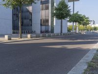 an empty street in front of some building on the other side of it with trees