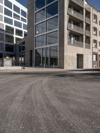 an empty street in a large city near several large apartment buildings and a sign on a sidewalk