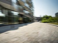 an abstract photograph of a man in a business suit riding down an empty street with his skateboard