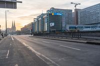 people walking across a empty street in the day time at sunrise with traffic lights on