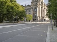 there is an empty street that has trees and a building in the background in this photo