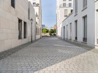 the empty street in front of a house with white walls and stone floors is lined with a bricked path