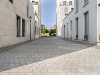 the empty street in front of a house with white walls and stone floors is lined with a bricked path