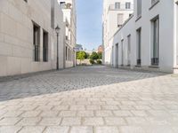 the empty street in front of a house with white walls and stone floors is lined with a bricked path