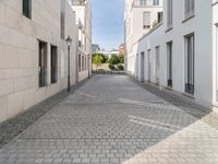 the empty street in front of a house with white walls and stone floors is lined with a bricked path