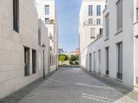 the empty street in front of a house with white walls and stone floors is lined with a bricked path