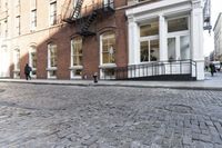 an empty street is seen in this photo in boston's west side neighborhood, with red brick sidewalks