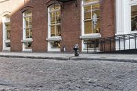 an empty street is seen in this photo in boston's west side neighborhood, with red brick sidewalks