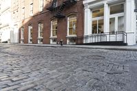an empty street is seen in this photo in boston's west side neighborhood, with red brick sidewalks