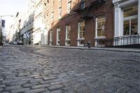 an empty street is seen in this photo in boston's west side neighborhood, with red brick sidewalks