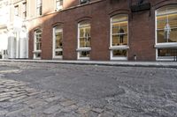 an empty street is seen in this photo in boston's west side neighborhood, with red brick sidewalks