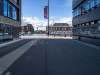 a very empty street in front of some buildings with a street flag flying in the sky