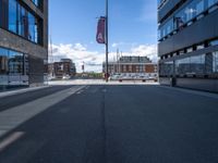 a very empty street in front of some buildings with a street flag flying in the sky